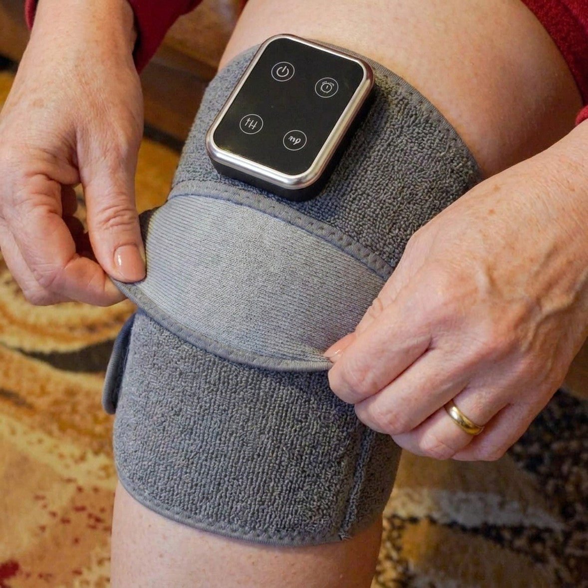 Hands fastening the strap of the Mendable Knee wrap